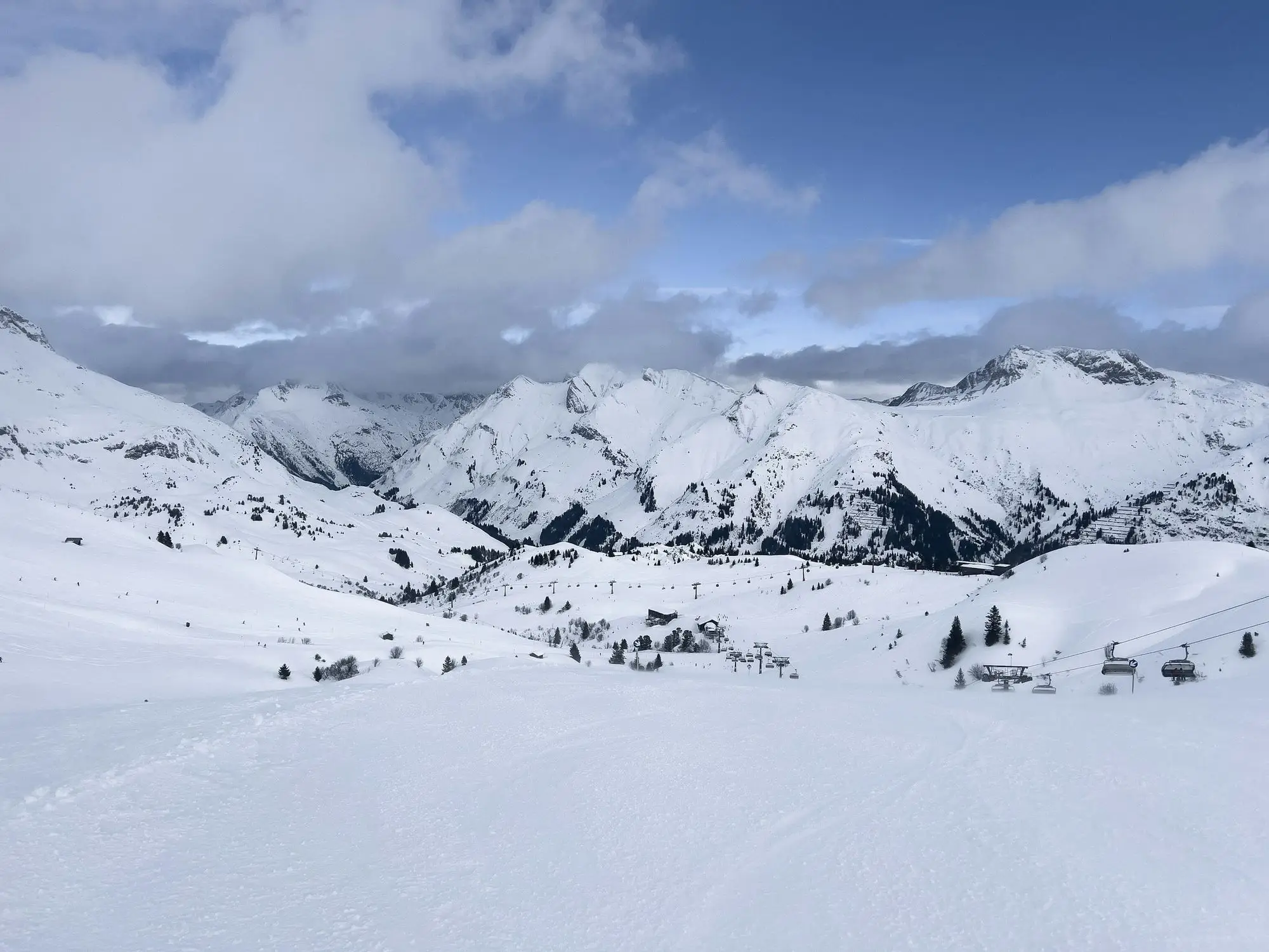 A sunny ski slope looking out over snowy mountains in Austria