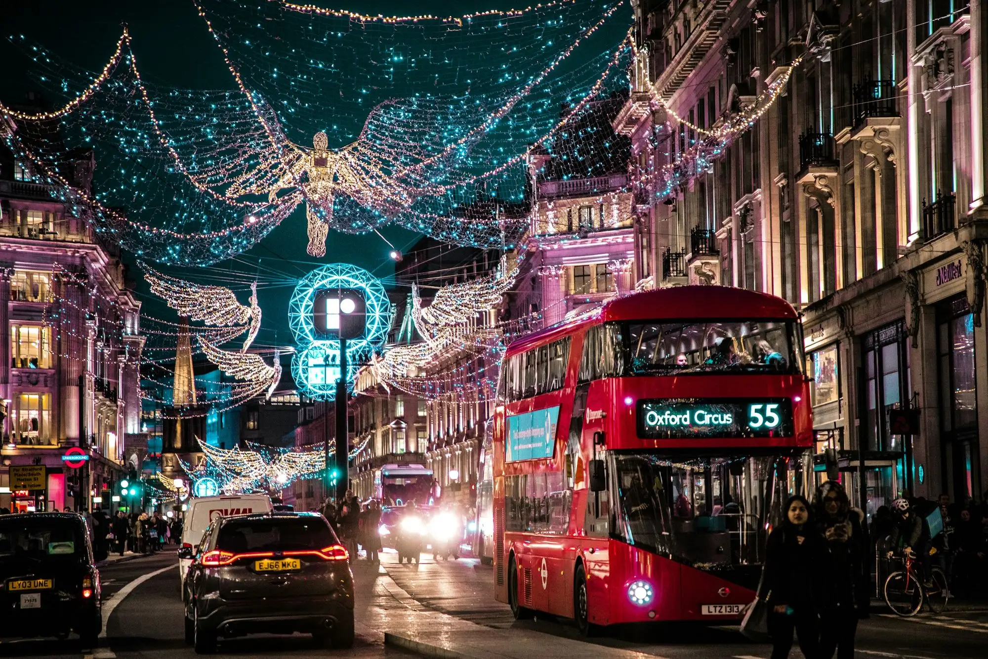 A red double-decker bus under the Christmas lights on Regent Street, London