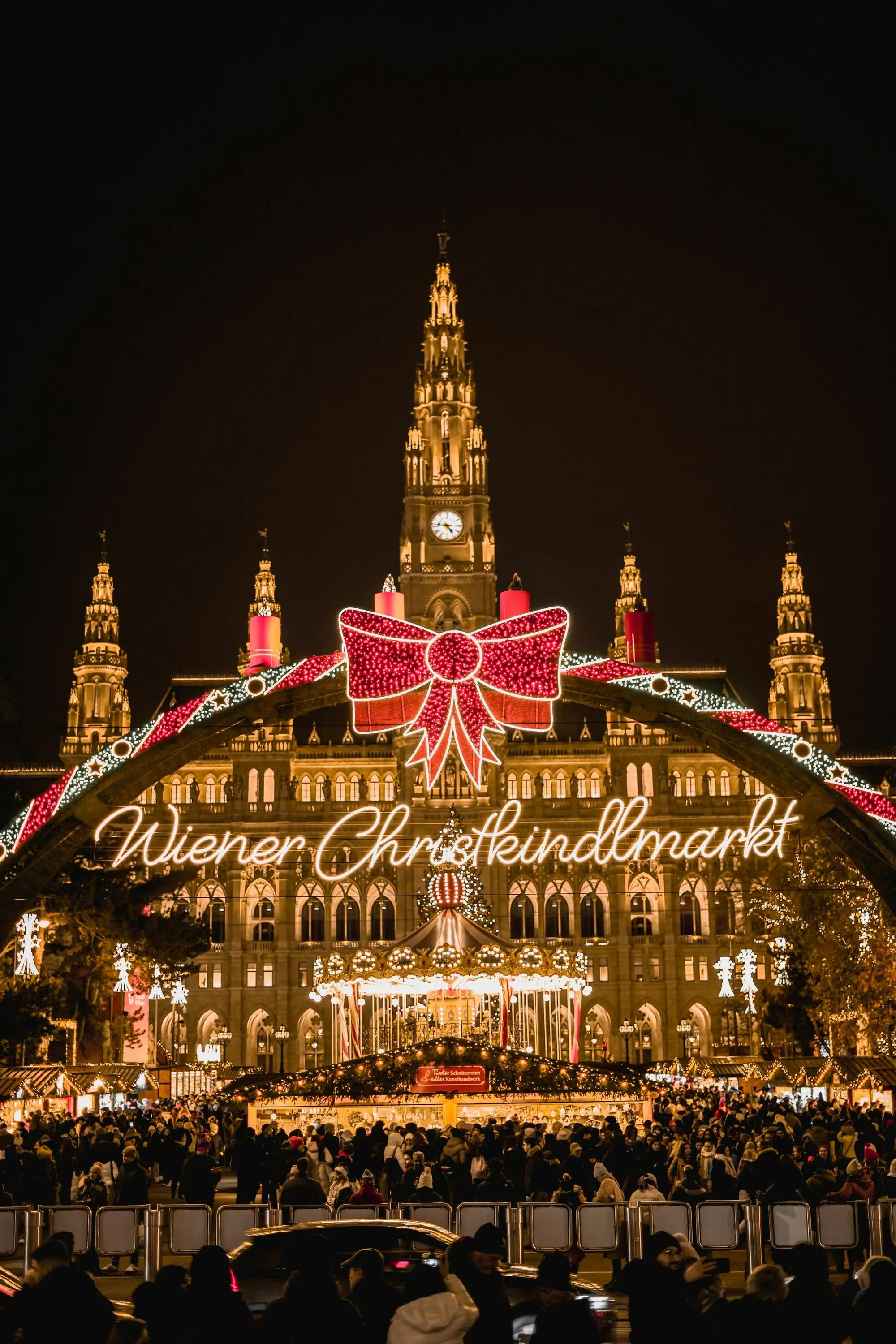 The illuminated Wiener Christkindlmarkt arch in front of Vienna's City Hall at night